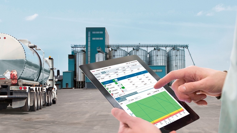 Man with iPad in front of food plant