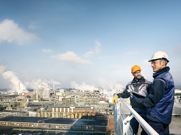 Dos ingenieros observan una gran planta industrial.